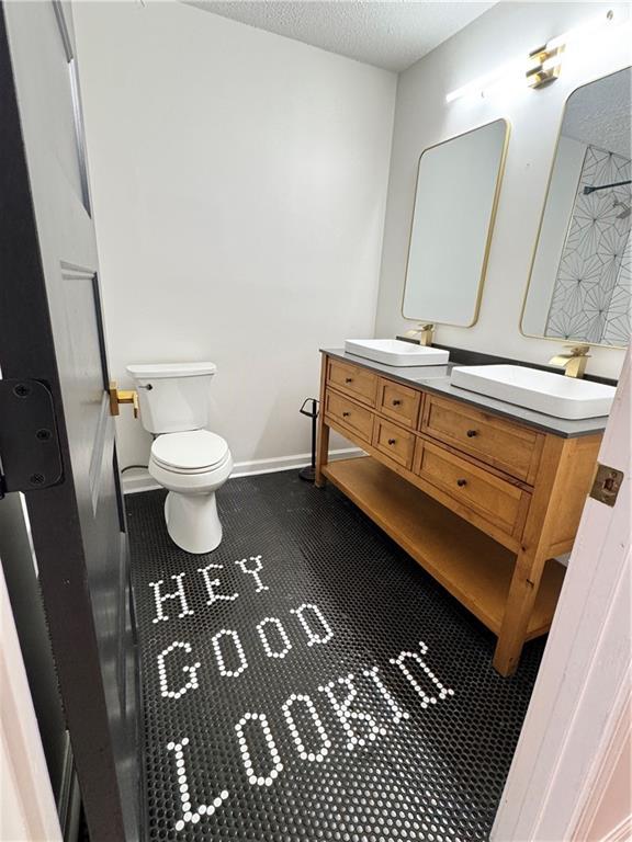215 Maplewood Dr SW, Calhoun, GA 30701 - full bath with double vanity, toilet, tile patterned floors, a shower, and a textured ceiling