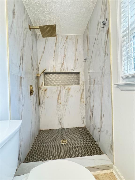 215 Maplewood Dr SW, Calhoun, GA 30701 - bathroom featuring toilet, a marble finish shower, and a textured ceiling