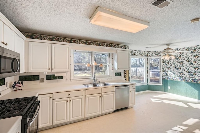 kitchen with sink, white cabinetry, a textured ceiling, appliances with stainless steel finishes, and ceiling fan