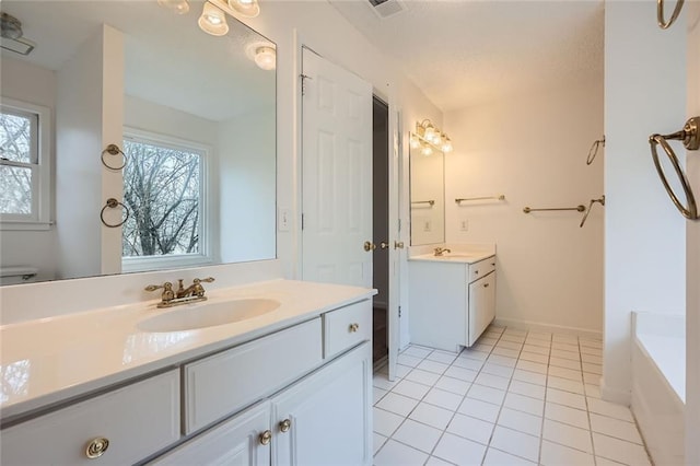 bathroom with tile patterned flooring, vanity, and a washtub