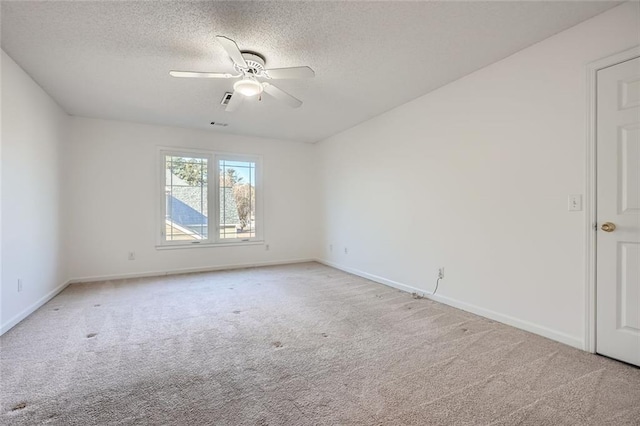 unfurnished room featuring ceiling fan, light carpet, and a textured ceiling