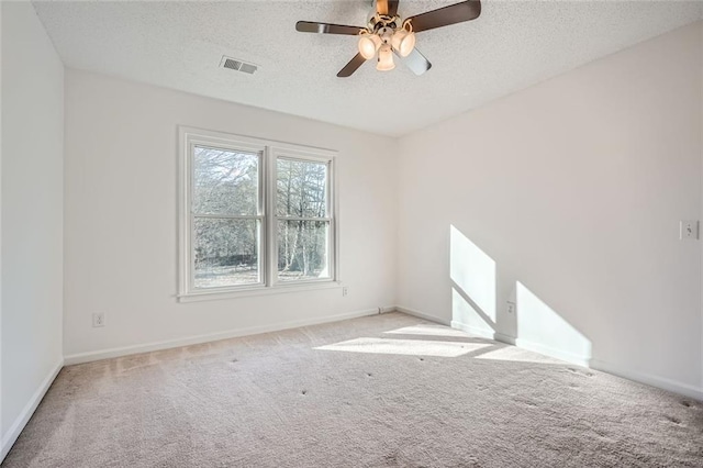 carpeted spare room with ceiling fan and a textured ceiling