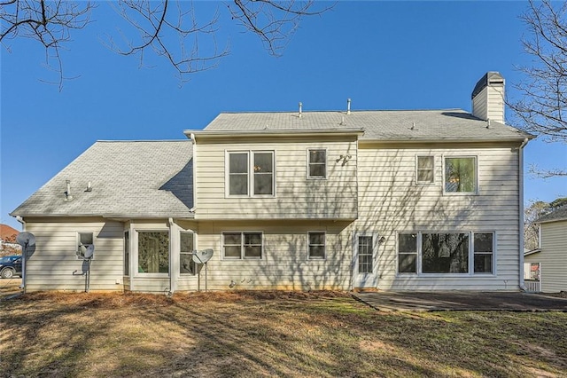 back of house featuring a lawn and a patio