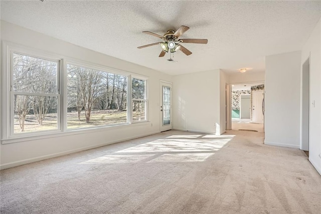 carpeted empty room featuring ceiling fan and a textured ceiling