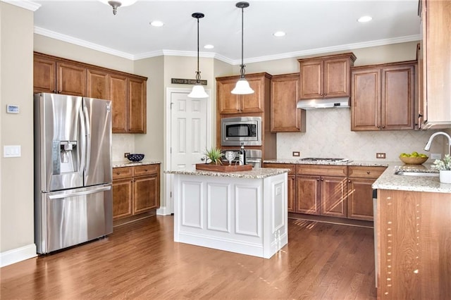 kitchen with tasteful backsplash, brown cabinetry, dark wood-style floors, stainless steel appliances, and a sink