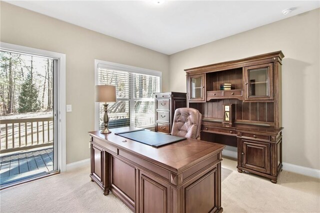 office area featuring baseboards and light colored carpet