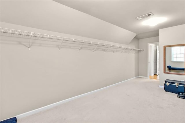 spacious closet featuring carpet, visible vents, and lofted ceiling