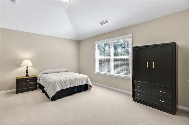 bedroom with light colored carpet, lofted ceiling, visible vents, and baseboards