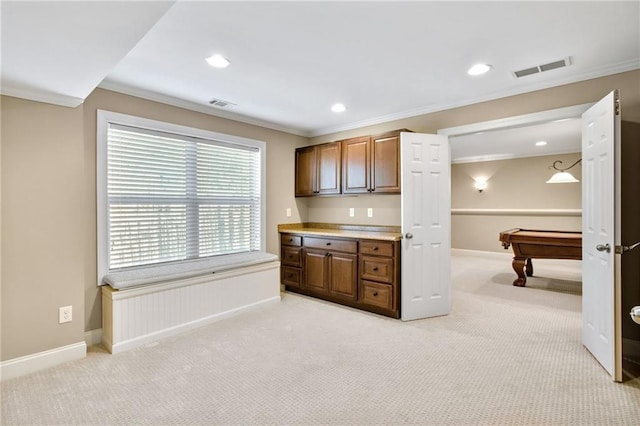 kitchen with light colored carpet, crown molding, visible vents, and baseboards