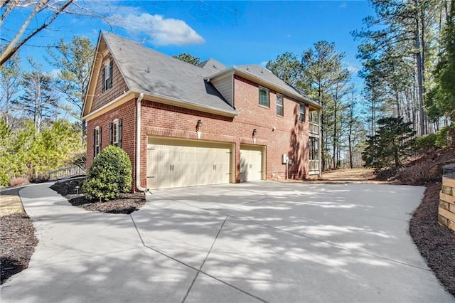 view of side of property featuring concrete driveway and brick siding