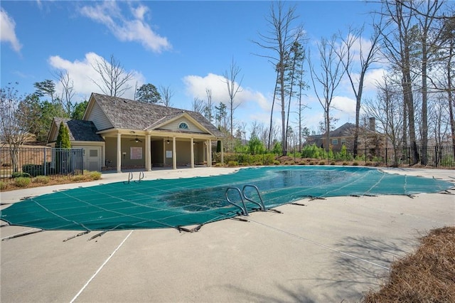 pool with a patio area and fence