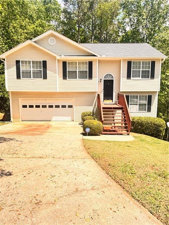 split foyer home featuring concrete driveway and a garage