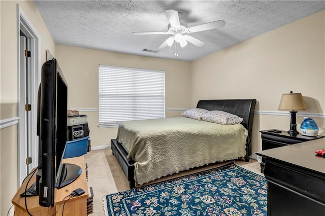 bedroom featuring visible vents, a textured ceiling, and light colored carpet