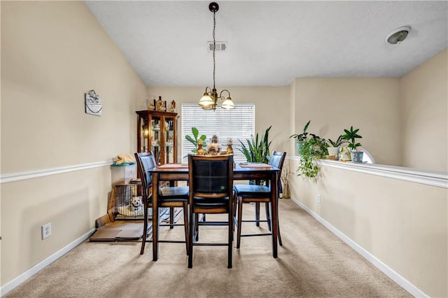 carpeted dining area with baseboards, visible vents, and a notable chandelier