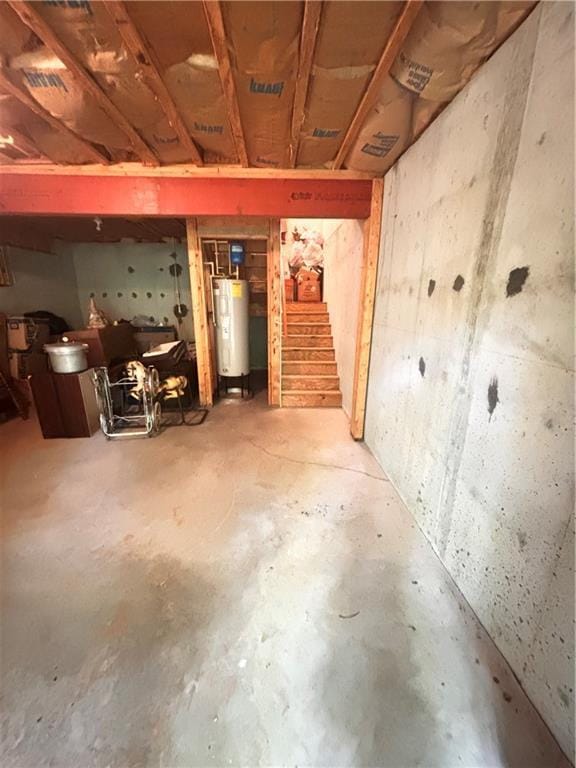 unfinished basement with water heater and stairway