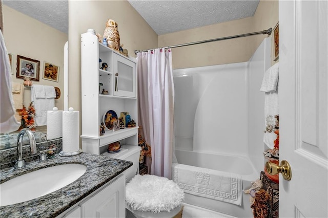 bathroom with a textured ceiling, vanity, and shower / bath combo