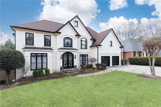 french country style house featuring french doors, a garage, and a front yard