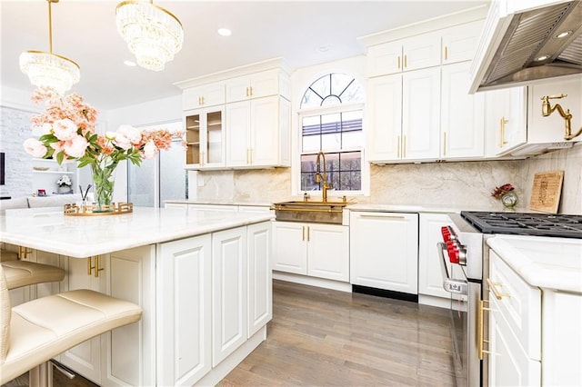 kitchen with dishwasher, white cabinets, custom exhaust hood, hanging light fixtures, and stainless steel range