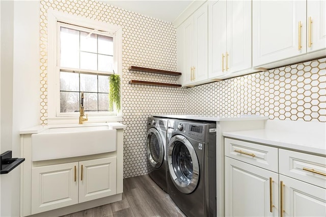 washroom with cabinets, sink, independent washer and dryer, and dark hardwood / wood-style floors