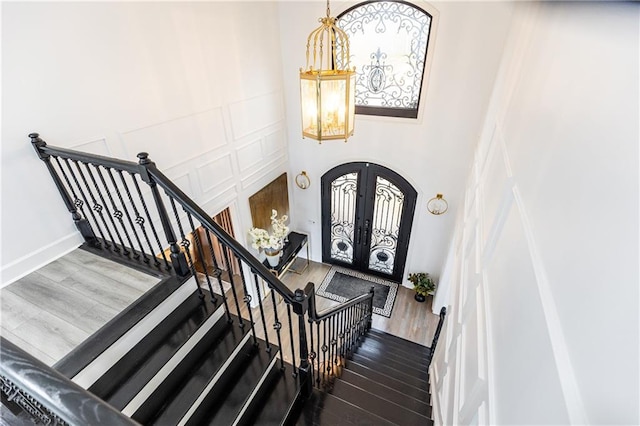 stairway with wood-type flooring and french doors