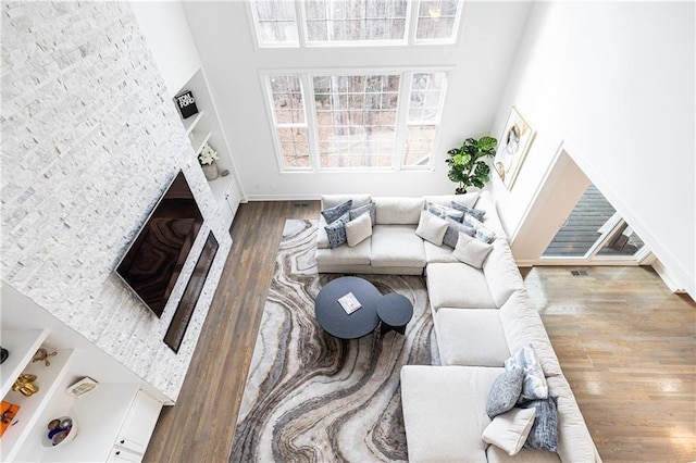 living room with wood-type flooring and a towering ceiling