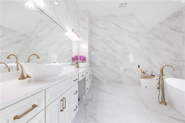 bathroom with vanity, lofted ceiling, and a bathtub