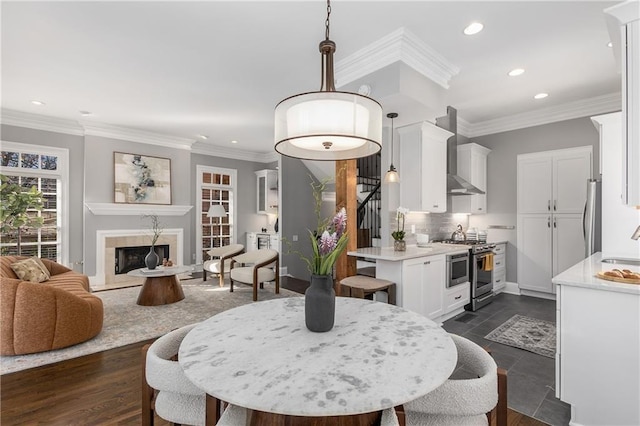 dining area with stairway, a fireplace, ornamental molding, and recessed lighting