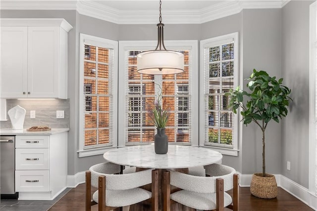 dining room with breakfast area, a wealth of natural light, crown molding, and baseboards