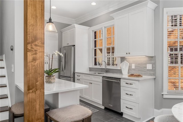 kitchen featuring stainless steel appliances, a sink, white cabinetry, and decorative backsplash