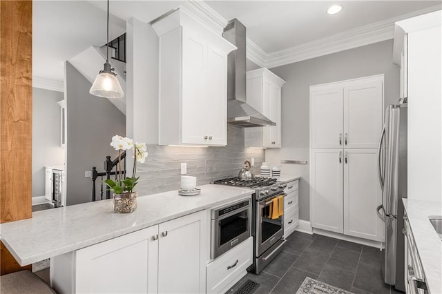 kitchen featuring appliances with stainless steel finishes, white cabinets, ornamental molding, and wall chimney range hood