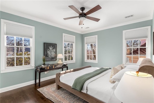 bedroom featuring crown molding, visible vents, baseboards, and wood finished floors