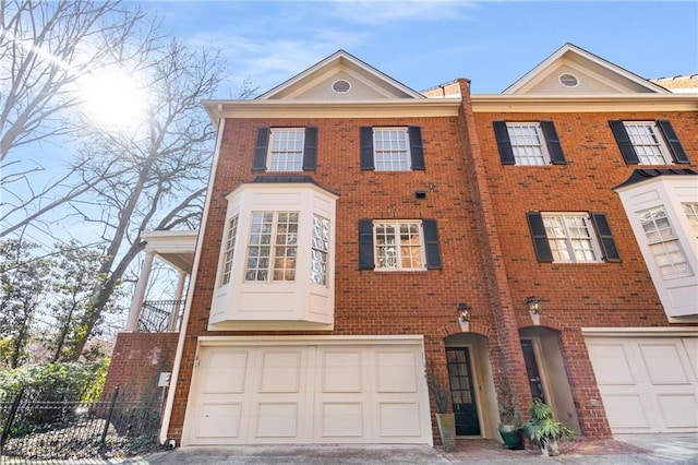 view of front of home with a garage, driveway, and brick siding