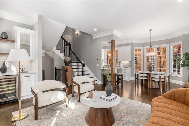 living area with stairs, wine cooler, crown molding, and wood finished floors