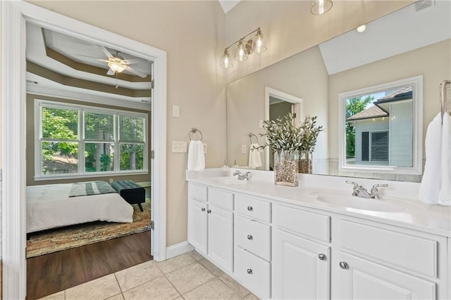 3232 Cates Ave NE, Brookhaven, GA 30319 - ensuite bathroom featuring tile patterned floors, double vanity, ceiling fan, baseboards, and a tray ceiling