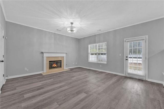 unfurnished living room with hardwood / wood-style flooring, ornamental molding, and a notable chandelier