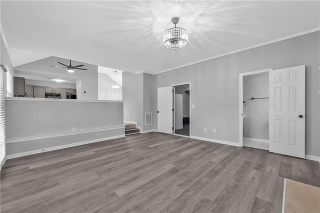 unfurnished living room featuring hardwood / wood-style flooring, crown molding, and ceiling fan with notable chandelier