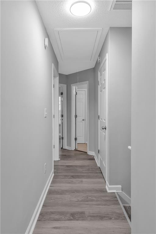 hallway featuring a textured ceiling and light wood-type flooring