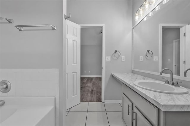 bathroom with tile patterned floors, vanity, and a tub