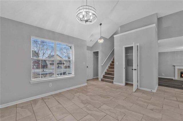 unfurnished living room featuring a chandelier and vaulted ceiling