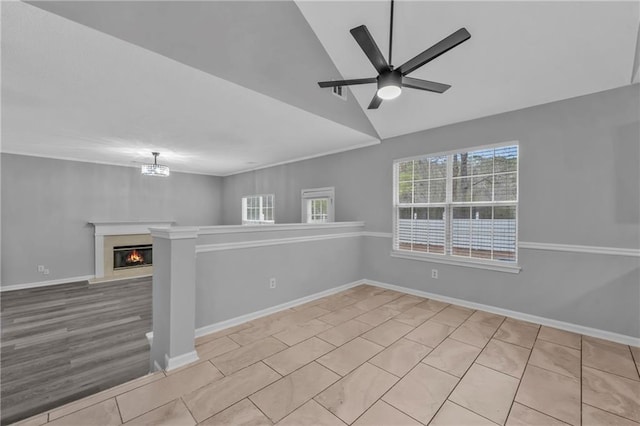 empty room with lofted ceiling, ceiling fan with notable chandelier, and light wood-type flooring