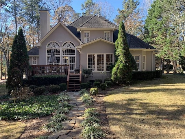 rear view of property featuring a lawn and a wooden deck