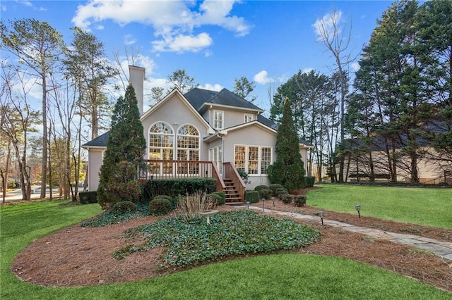 view of front facade with a front yard and a deck