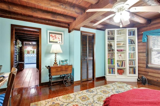 bedroom with ceiling fan, beamed ceiling, wood ceiling, log walls, and a closet