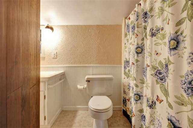 bathroom featuring toilet, tile patterned flooring, and curtained shower