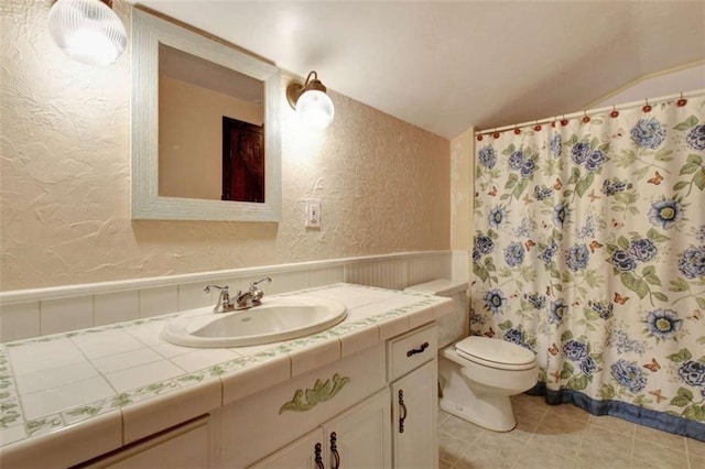 bathroom with toilet, tile patterned flooring, and vanity