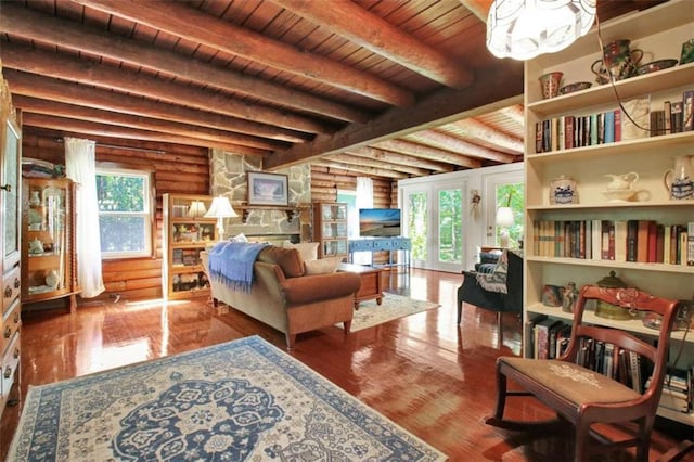 living area with wooden ceiling, hardwood / wood-style floors, rustic walls, and beam ceiling