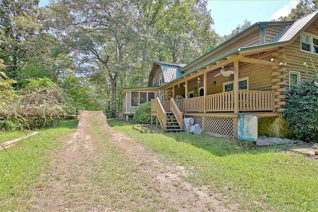 exterior space with ceiling fan and a yard