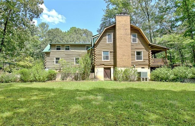 back of property featuring a lawn and central AC