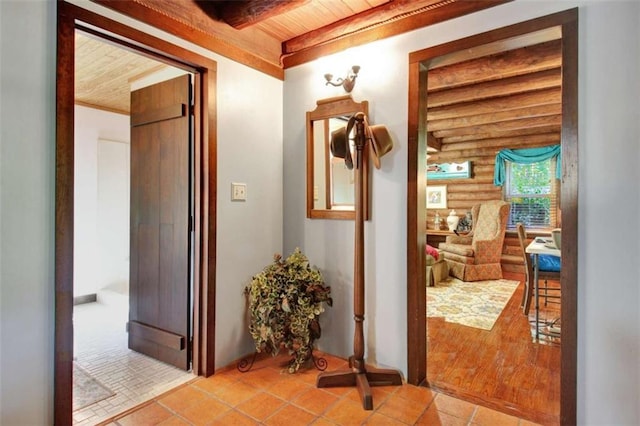 hallway with light tile patterned floors, wood ceiling, beamed ceiling, and log walls