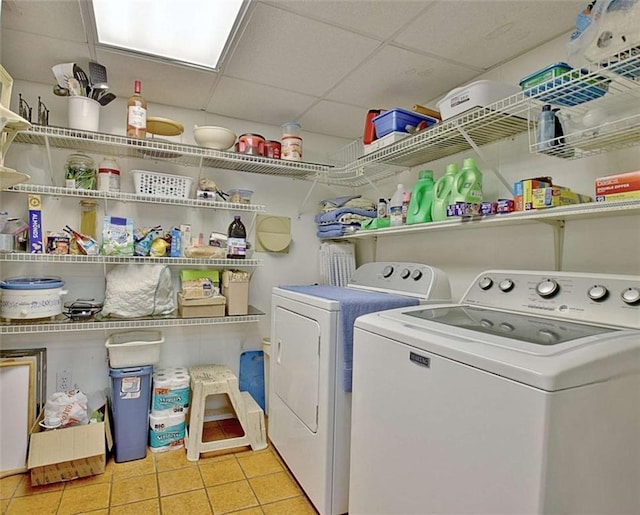 washroom with light tile patterned floors and washing machine and dryer